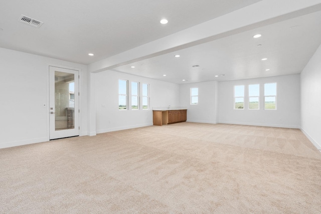 unfurnished living room featuring light colored carpet, visible vents, baseboards, and recessed lighting