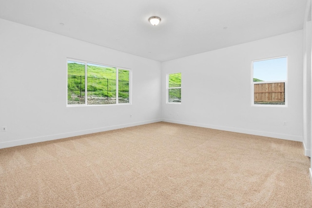 spare room featuring carpet flooring and baseboards