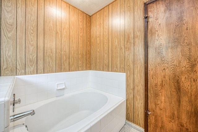 bathroom with a garden tub and wooden walls