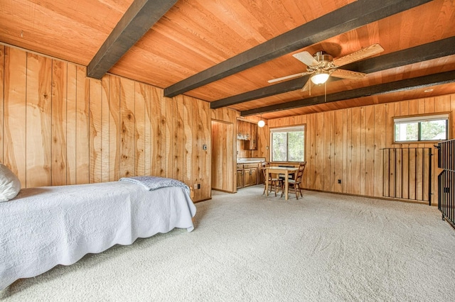 carpeted bedroom with wood walls, wood ceiling, and beamed ceiling