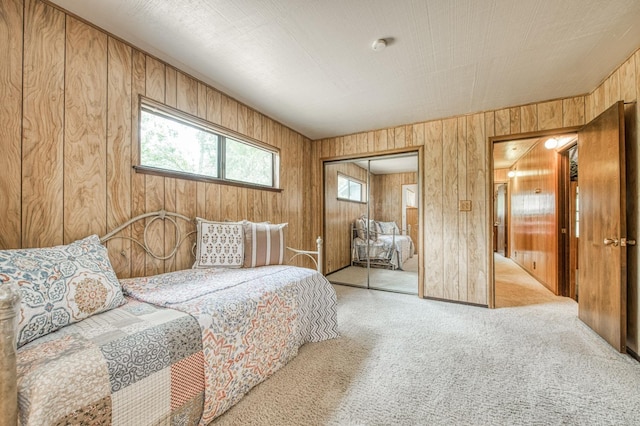 bedroom with carpet floors, a closet, and wooden walls