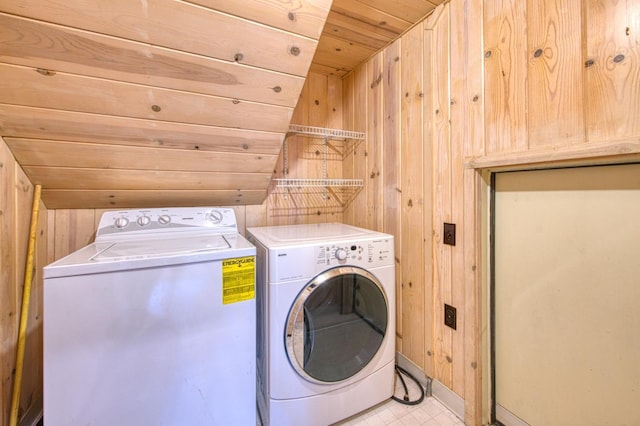 laundry room with wood ceiling, laundry area, wooden walls, and separate washer and dryer