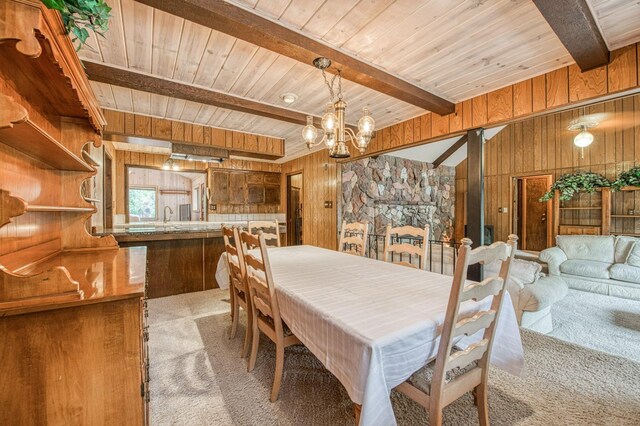 carpeted dining room with wooden ceiling, beamed ceiling, and wooden walls