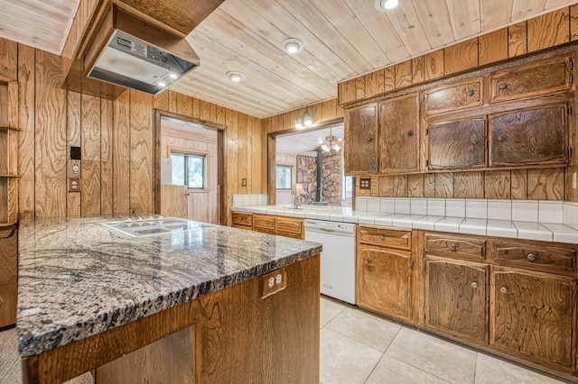 kitchen with wooden ceiling, white appliances, wood walls, and light tile patterned flooring