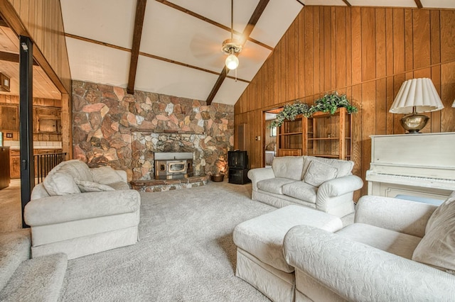 living room featuring a wood stove, wooden walls, a ceiling fan, and carpet flooring