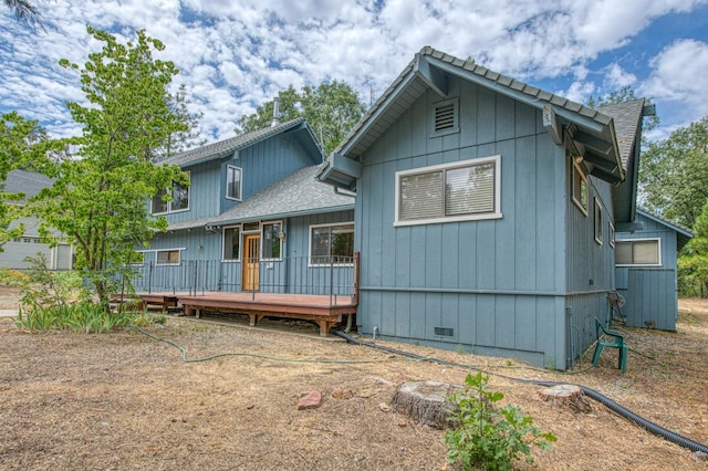 back of property featuring a deck, crawl space, and roof with shingles