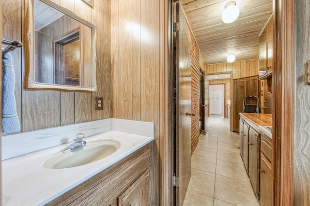 bathroom featuring wooden ceiling, tile patterned flooring, vanity, and wooden walls