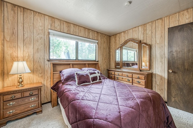 bedroom with light carpet and wood walls