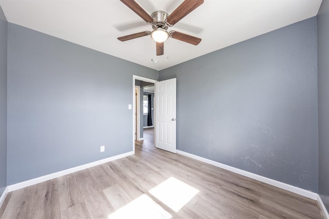 empty room with ceiling fan, baseboards, and wood finished floors