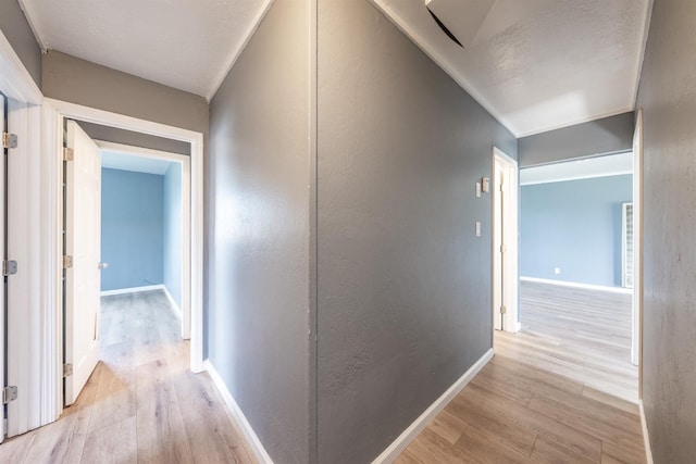 corridor with baseboards and light wood-style flooring