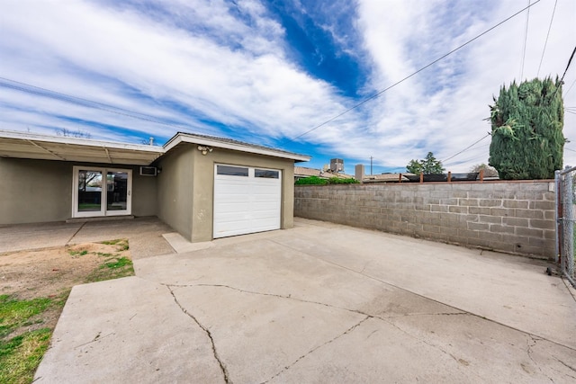 view of patio with driveway, an attached garage, and fence