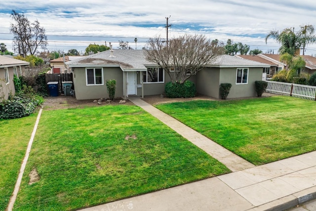 ranch-style home featuring stucco siding, a fenced backyard, a front lawn, and a shingled roof