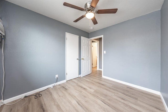 unfurnished bedroom with a ceiling fan, wood finished floors, and baseboards