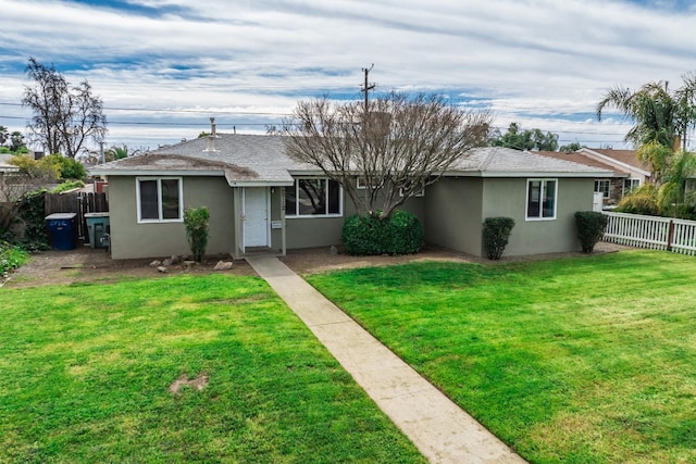 single story home featuring a front lawn, fence, roof with shingles, and stucco siding