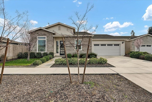 view of front facade with a garage, driveway, and fence