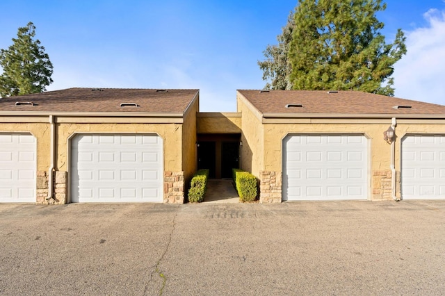 view of front facade featuring a shingled roof and stucco siding