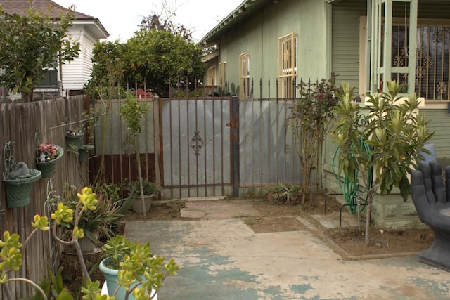 view of gate with a patio and fence