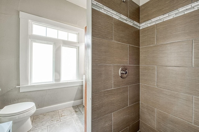 full bathroom featuring tiled shower, tile patterned floors, toilet, and baseboards