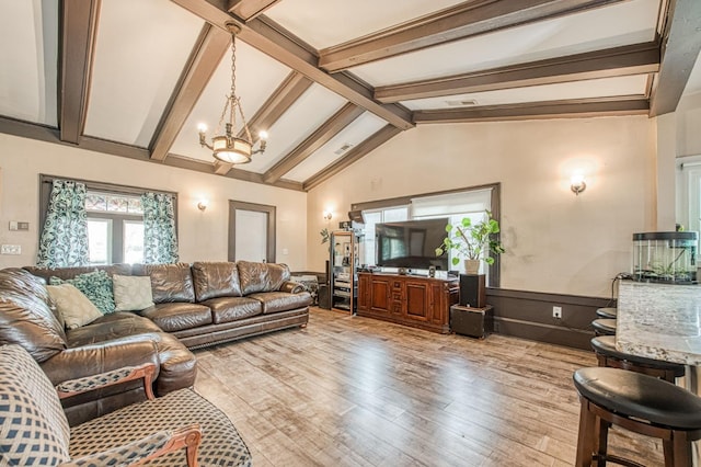 living area with vaulted ceiling with beams, wainscoting, a notable chandelier, and light wood finished floors