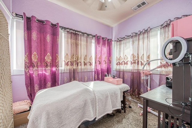 carpeted bedroom with visible vents and a ceiling fan