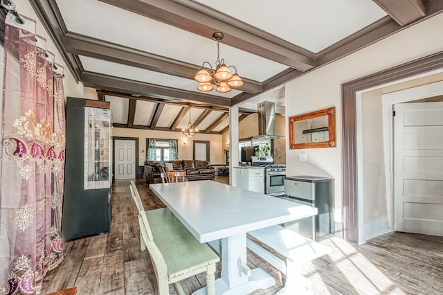 kitchen featuring gas stove, dark wood-style flooring, a notable chandelier, and wall chimney range hood