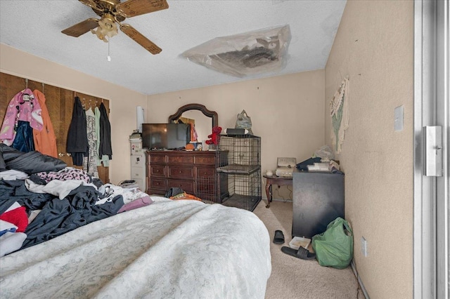 bedroom with carpet floors, ceiling fan, and a textured ceiling