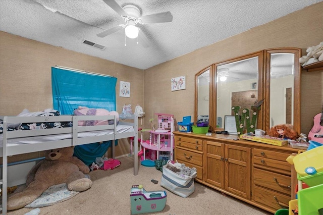 bedroom featuring light colored carpet, visible vents, and a textured ceiling