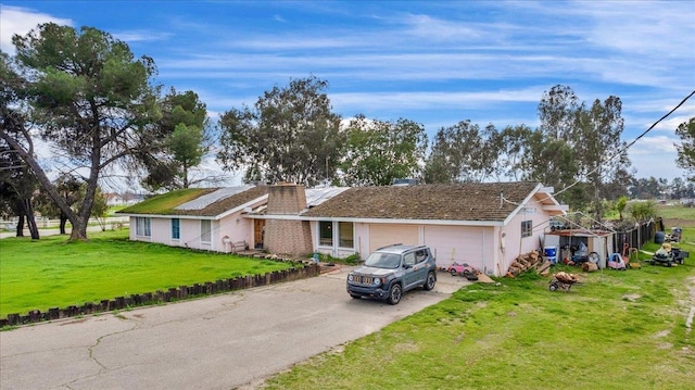 ranch-style home with a garage, aphalt driveway, and a front yard