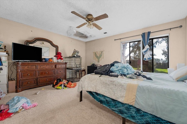 carpeted bedroom with visible vents, ceiling fan, and a textured ceiling