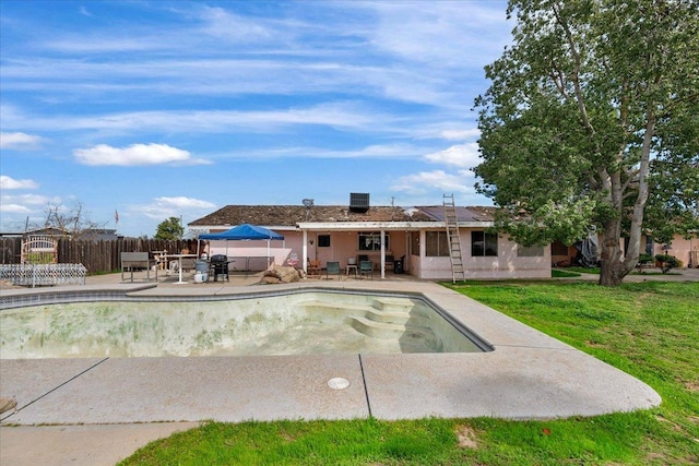 view of pool with a yard, a patio area, and fence