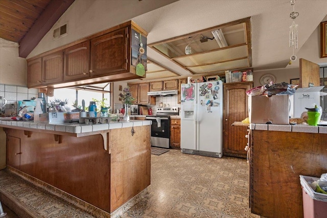 kitchen with tasteful backsplash, tile countertops, a peninsula, stainless steel electric stove, and white fridge with ice dispenser