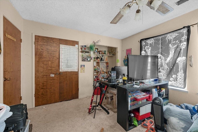 office with a textured ceiling, carpet, and a ceiling fan