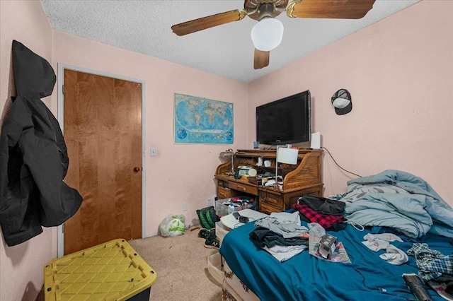 carpeted bedroom featuring a ceiling fan and a textured ceiling