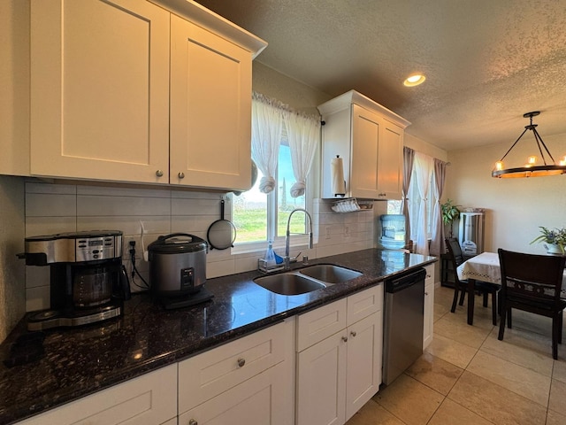 kitchen featuring light tile patterned floors, white cabinetry, decorative backsplash, dishwasher, and a sink