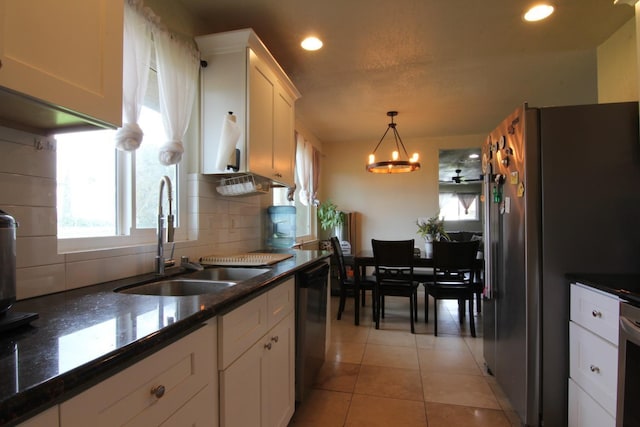 kitchen featuring light tile patterned floors, dishwashing machine, a sink, freestanding refrigerator, and decorative backsplash