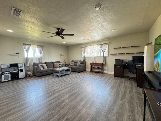 living area featuring recessed lighting, a textured ceiling, visible vents, ceiling fan, and wood finished floors