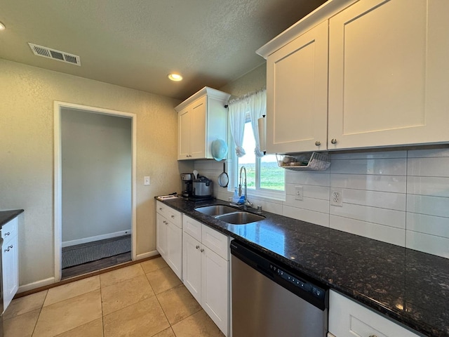 kitchen featuring light tile patterned floors, white cabinets, visible vents, stainless steel dishwasher, and a sink