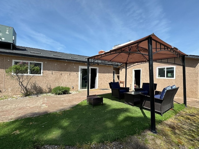 back of property featuring central AC, a patio area, a gazebo, an outdoor hangout area, and stucco siding