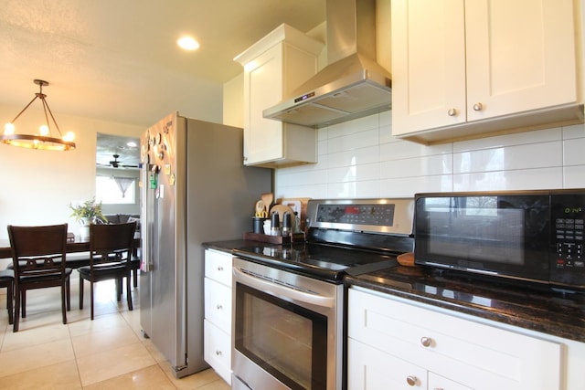 kitchen with stainless steel appliances, white cabinets, wall chimney range hood, and tasteful backsplash