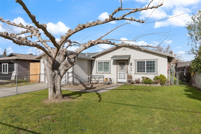 view of front of house with a front lawn, decorative driveway, fence, and stucco siding