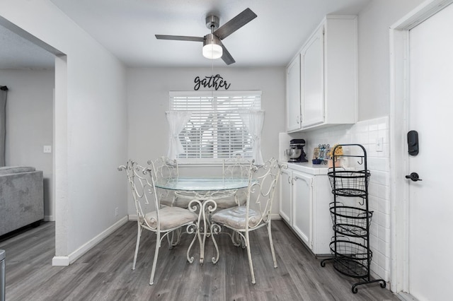 dining area with a ceiling fan, baseboards, and wood finished floors