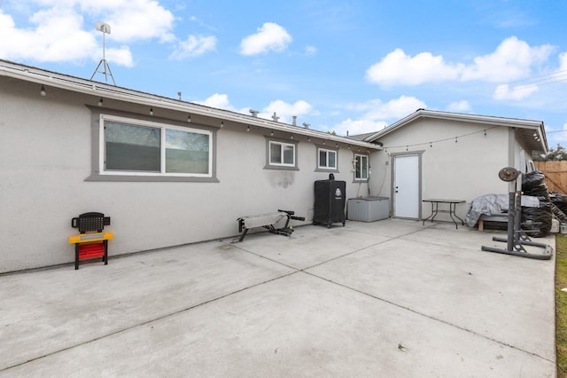 back of property with a patio area, fence, and stucco siding