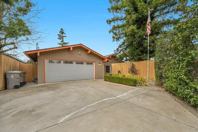 garage with driveway and fence