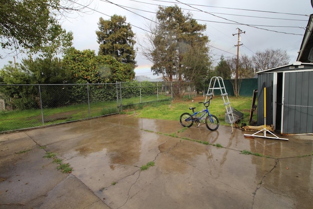 view of yard with an outbuilding, a fenced backyard, a patio, and a storage unit