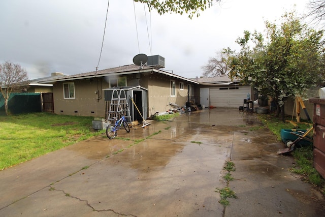 rear view of house with central air condition unit, fence, crawl space, a lawn, and stucco siding