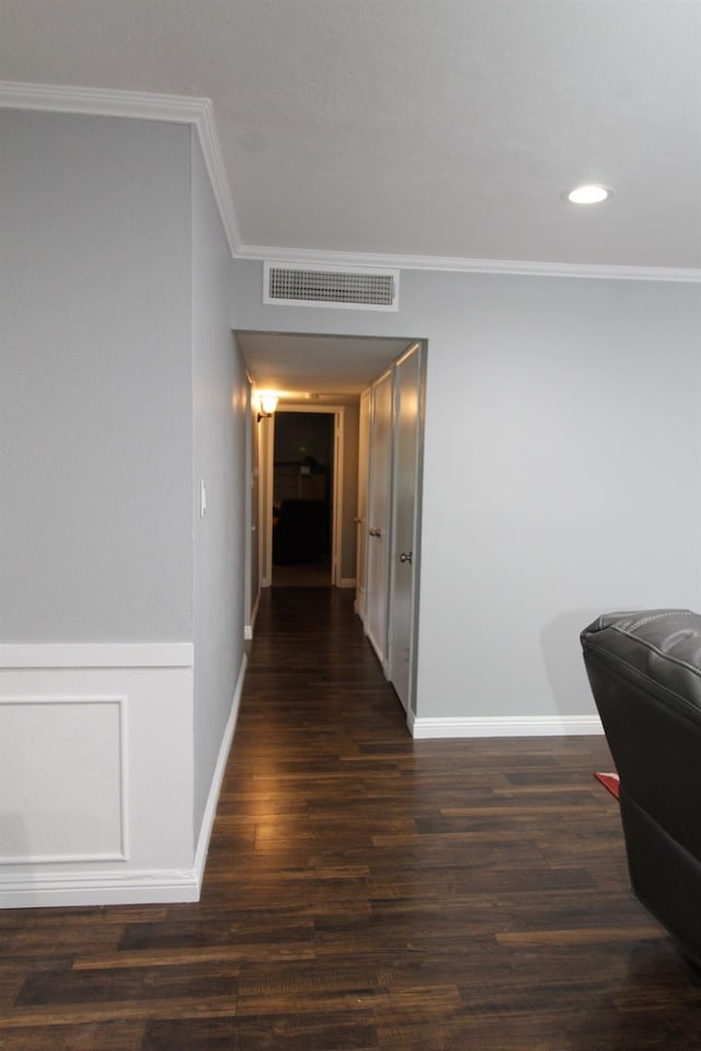 hallway featuring crown molding, recessed lighting, baseboards, wood finished floors, and visible vents