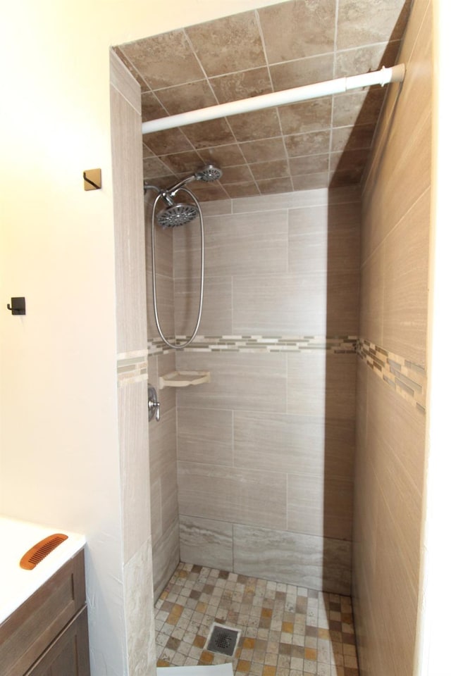 bathroom featuring a tile shower and vanity