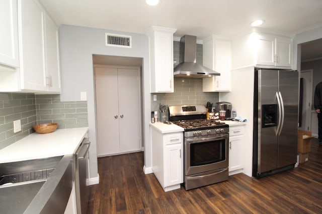 kitchen with wall chimney range hood, stainless steel appliances, dark wood finished floors, and backsplash