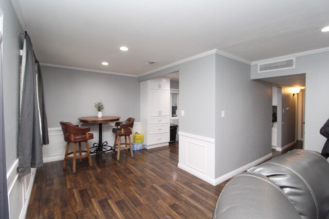 living area with dark wood-style flooring, visible vents, ornamental molding, and recessed lighting