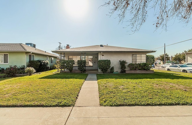 view of front of property featuring a front lawn and stucco siding